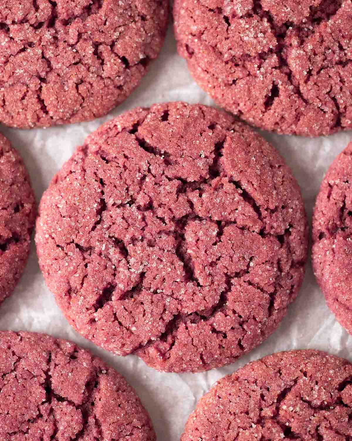 Close up of strawberry cookies on crumpled parchment paper.