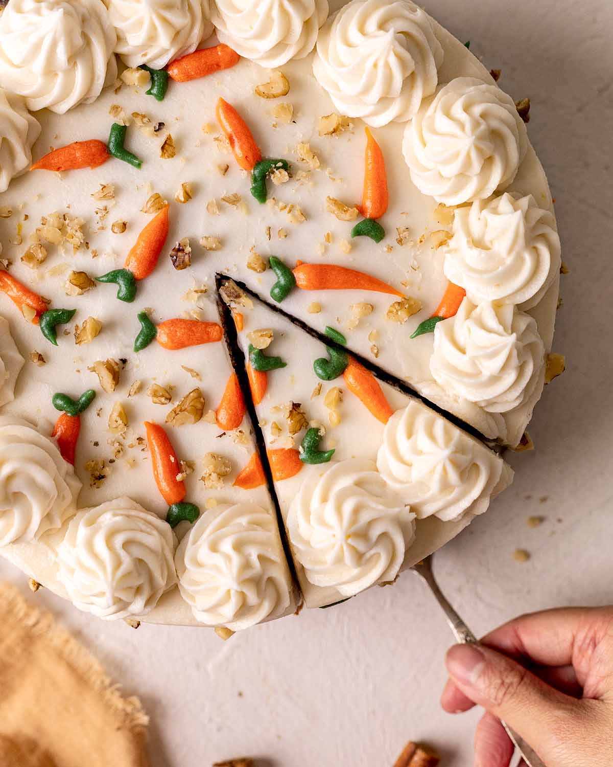 Overhead image of carrot cake decorated with buttercream piped to look like mini carrots.