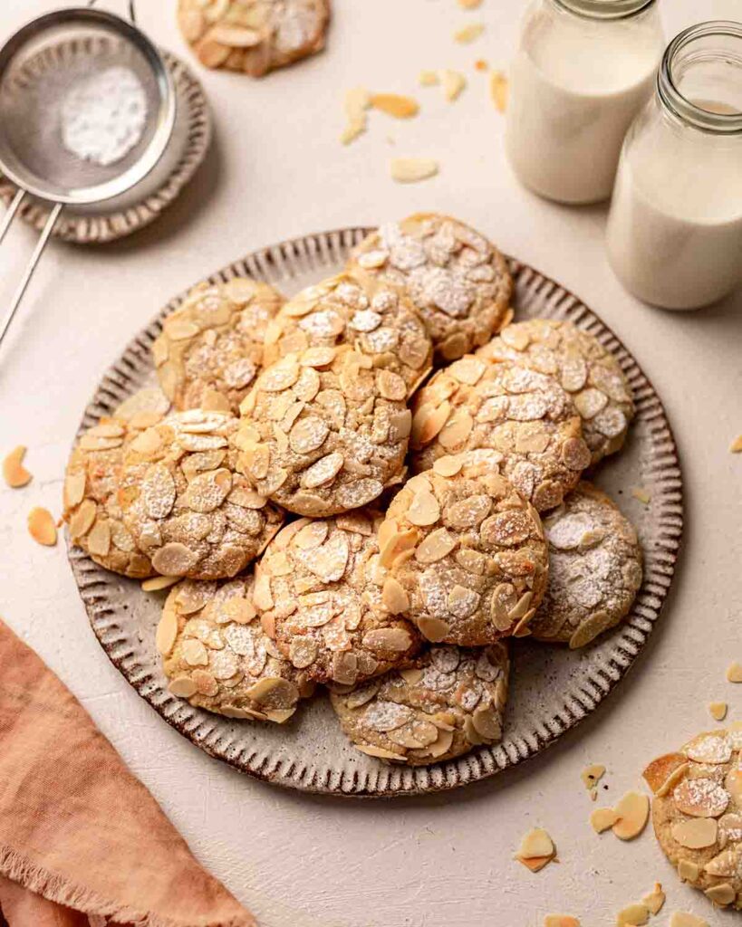 Plate of almond cookies coated generously in flaked almonds.