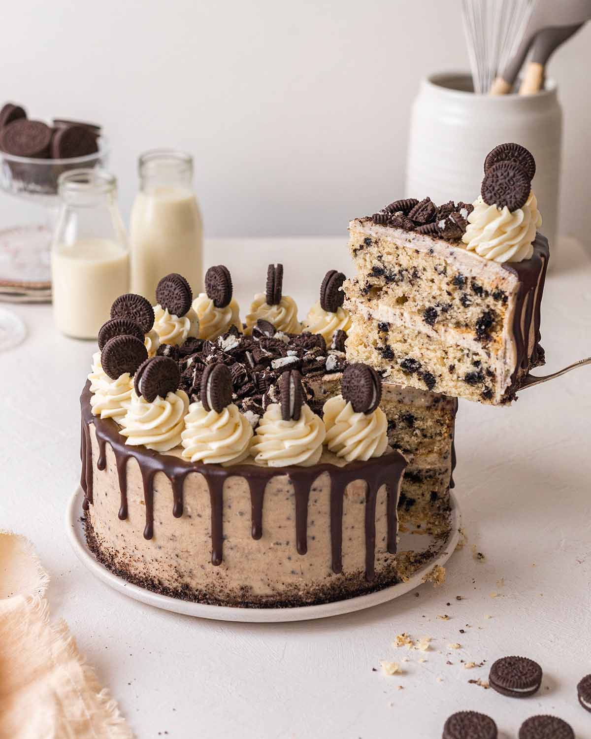 Vegan oreo cake on with slice coming out revealing 2 layers.