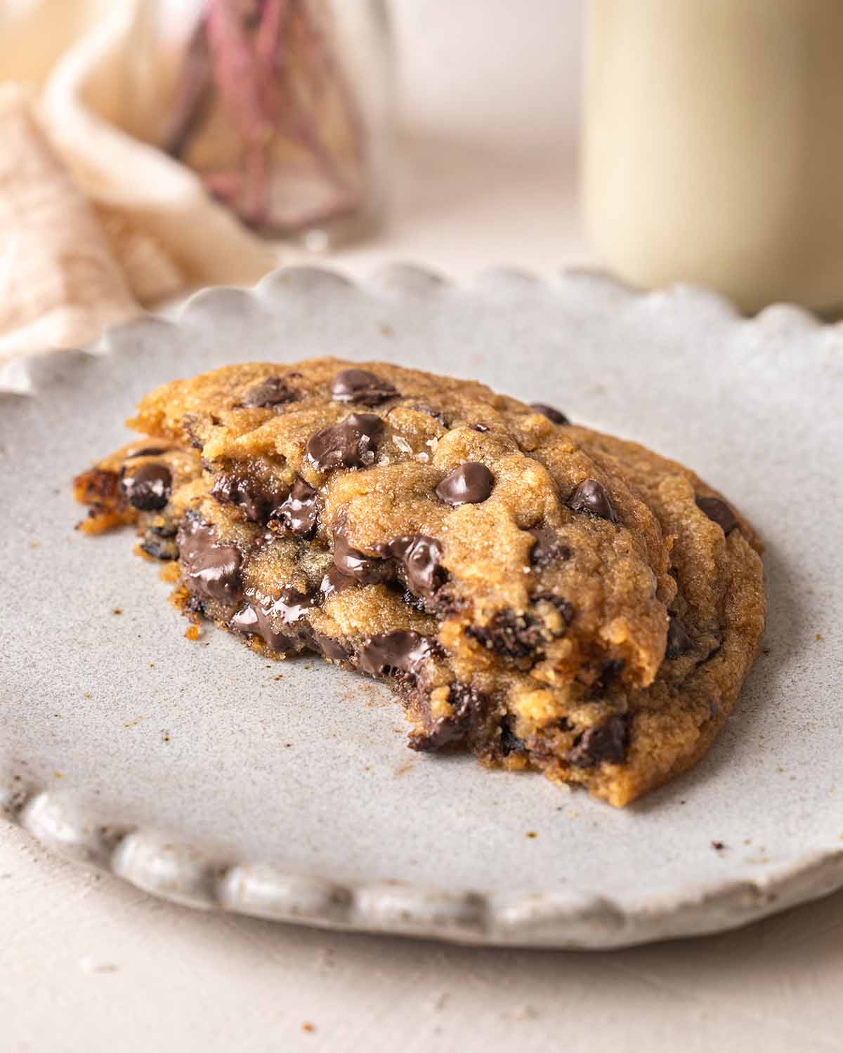 Large cookie split in half sitting on top of each other showing gooey interior and melty chocolate chips.