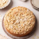 Simple one-layer cake with lots of toasted sliced almonds on top.