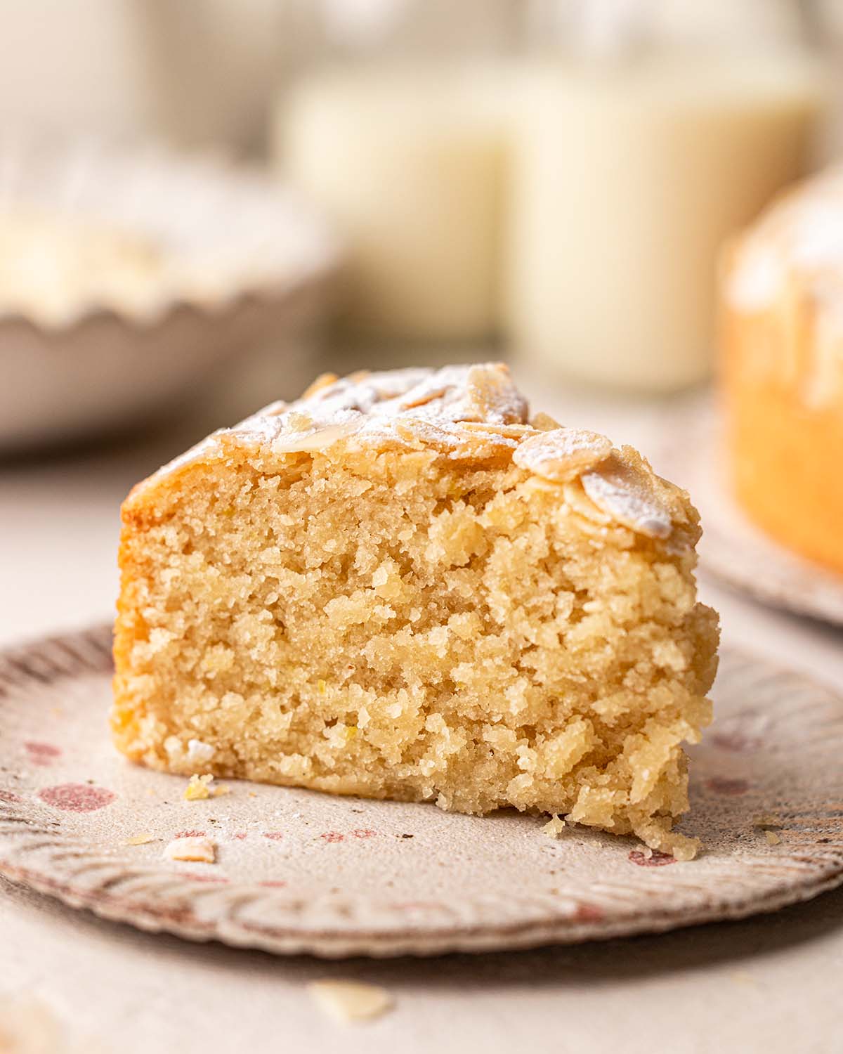 Slice of almond cake showing golden and fluffy texture.