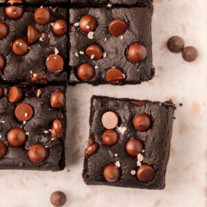 Brownies on parchment paper with the corner brownie popping out.