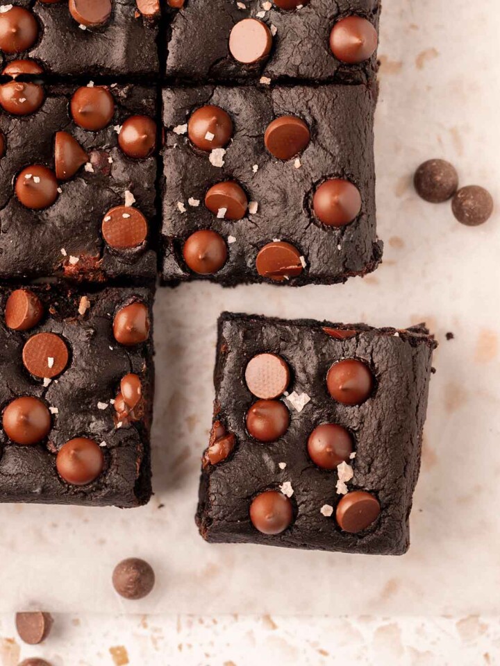 Brownies on parchment paper with the corner brownie popping out.