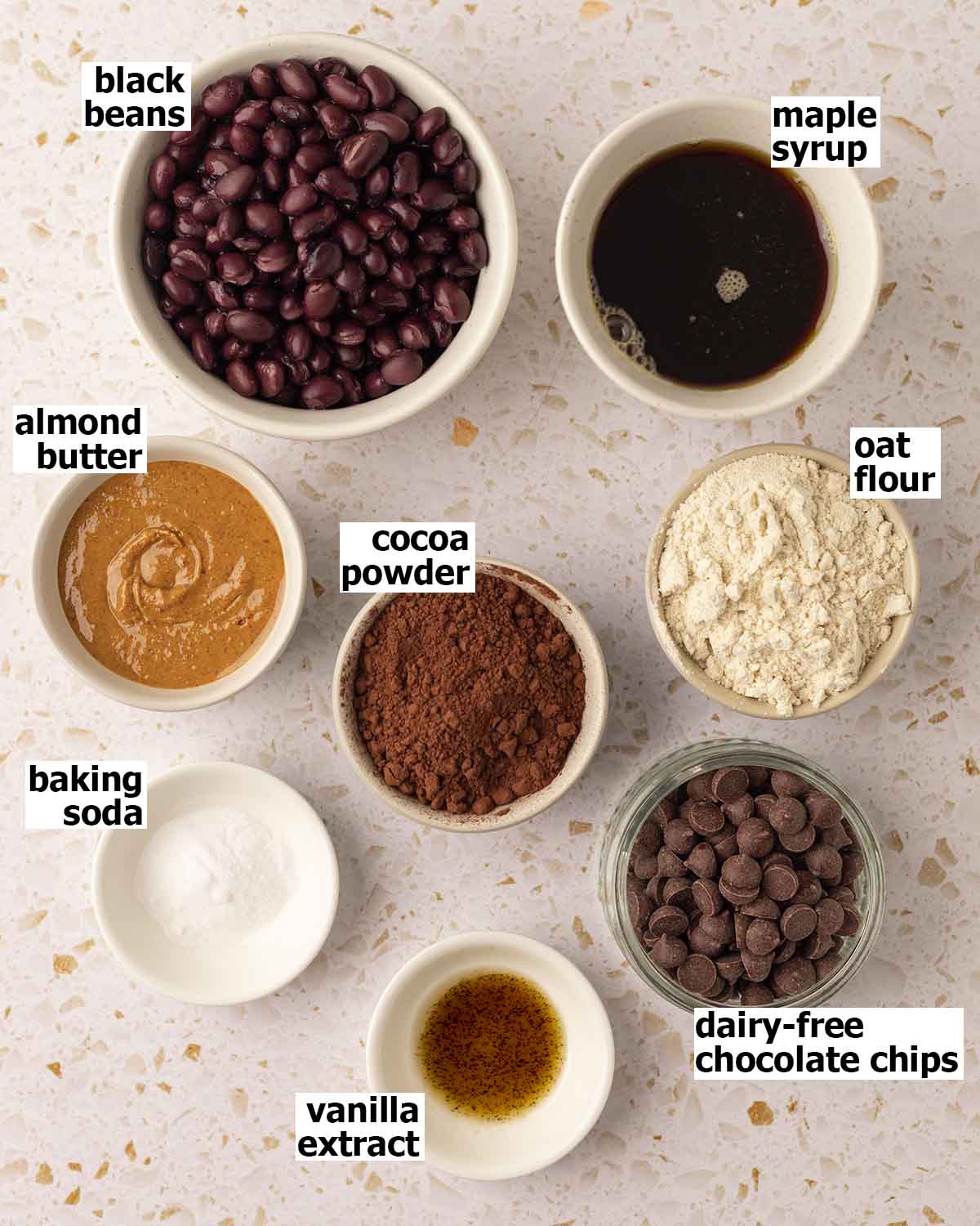 Flat-lay of ingredients for black bean brownies arranged in small dishes.