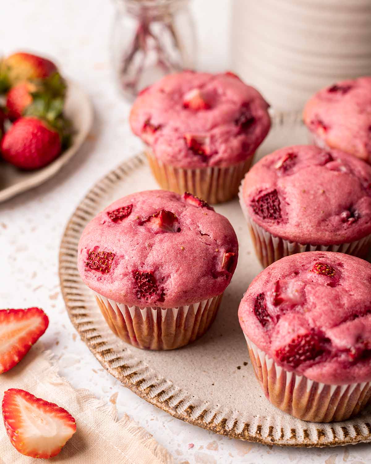 Plate of pink-colored strawberry muffins.
