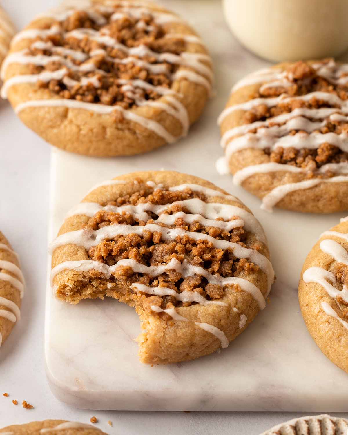 Close-up of one coffee cake cookie with bite taken out showing soft and thick texture.