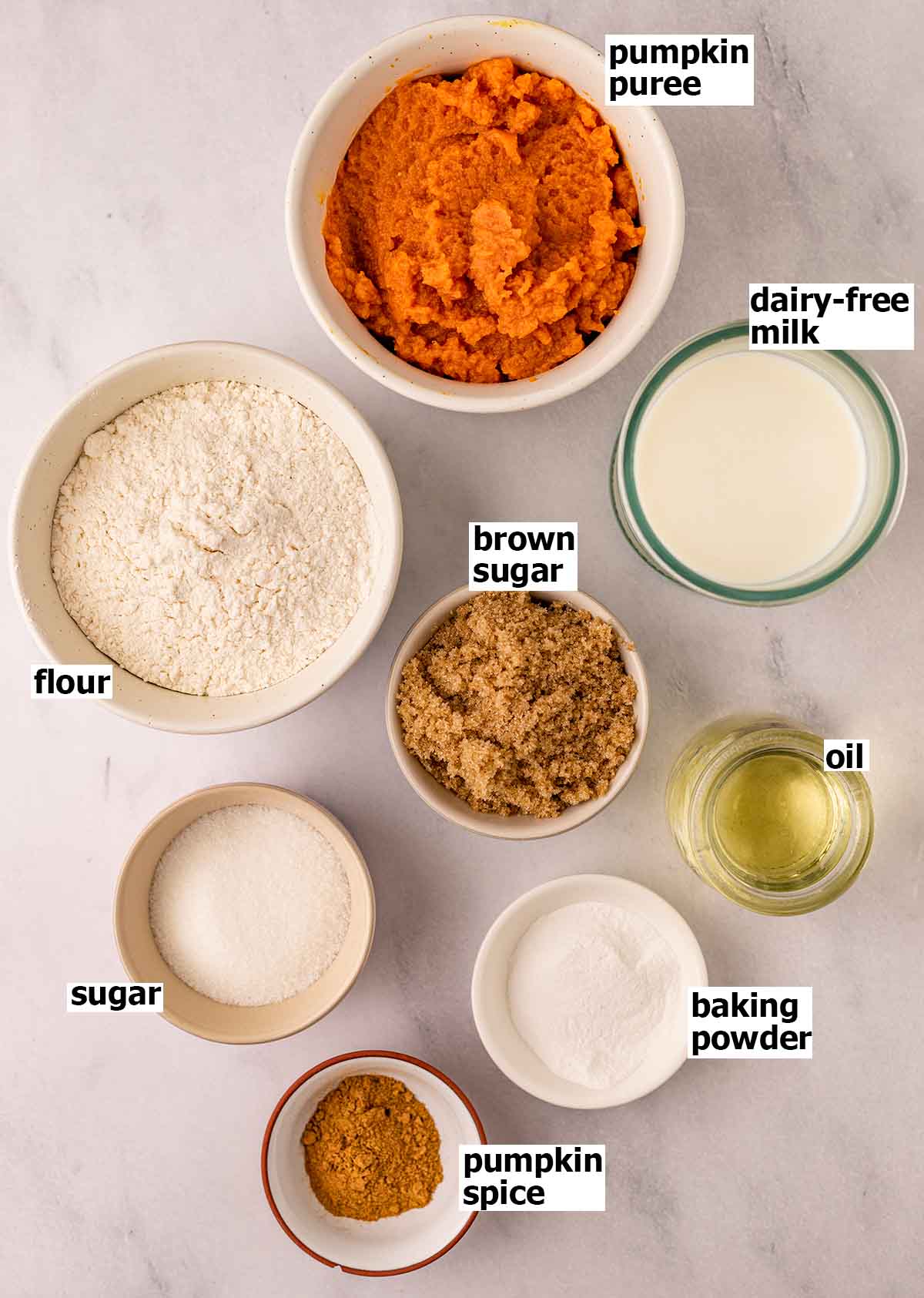 Flat-lay of eight ingredients for the vegan pumpkin cupcakes.