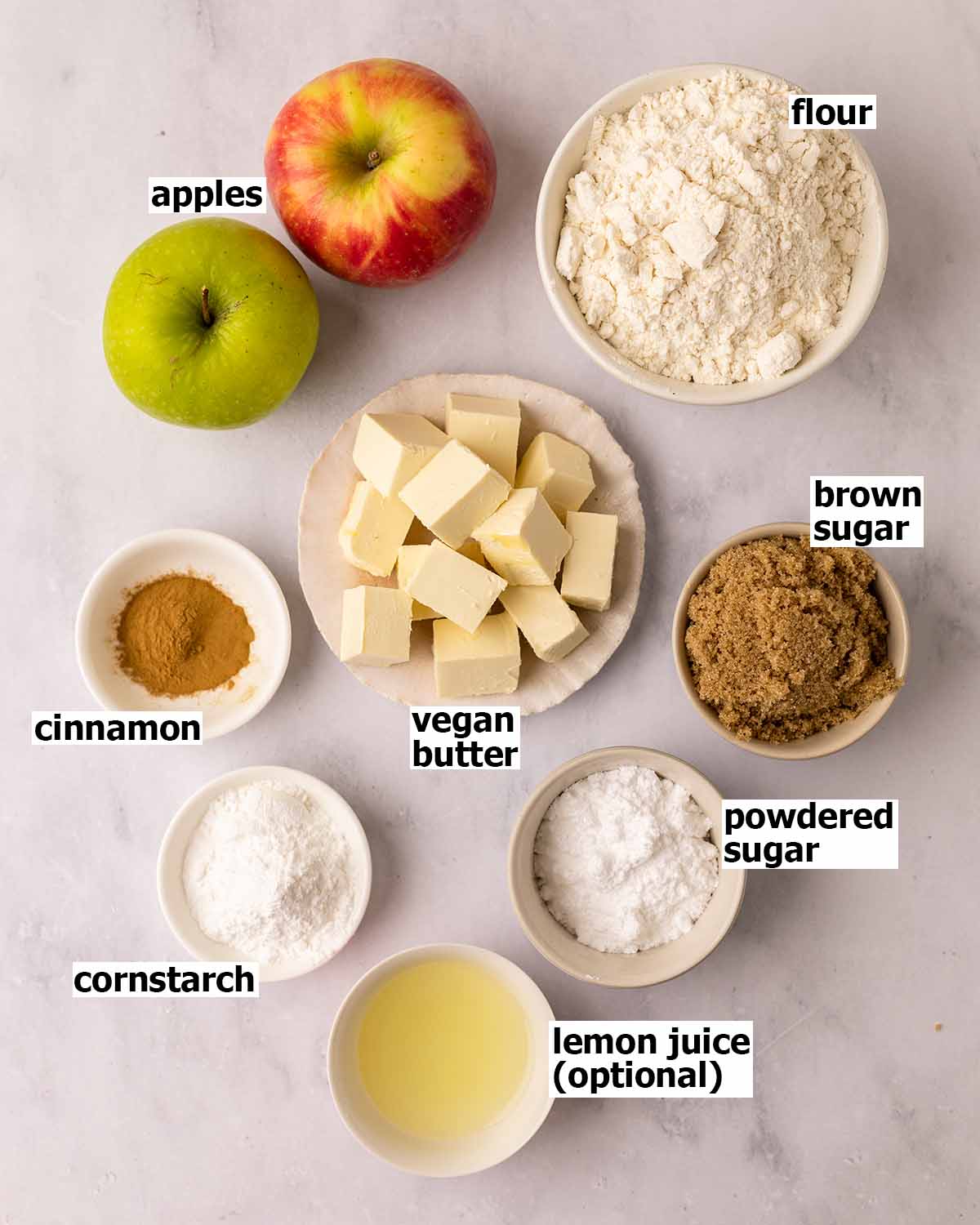 Flat-lay of ingredients in small dishes for the mini apple tarts.