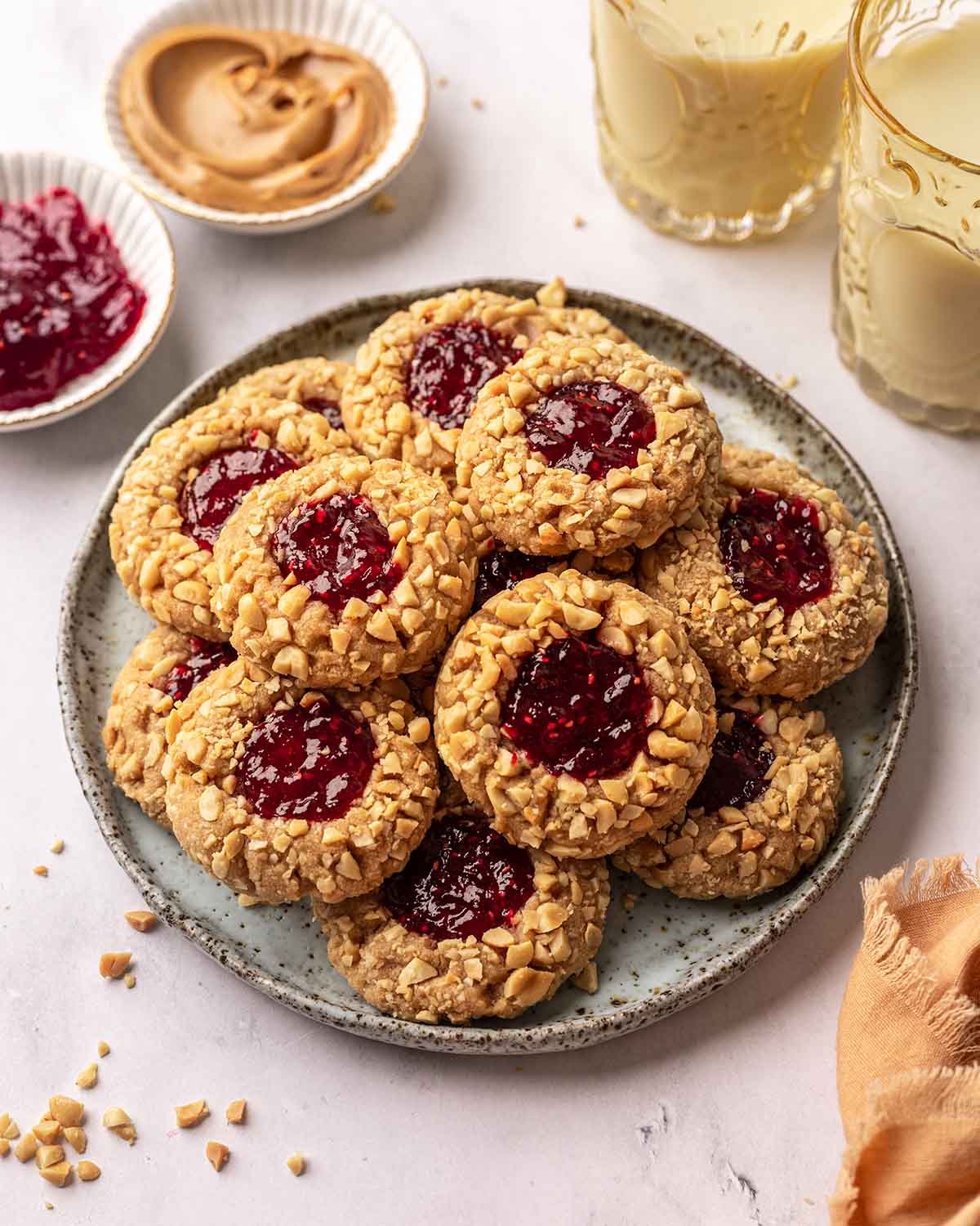 Peanut butter and jelly cookies on speckled plate.