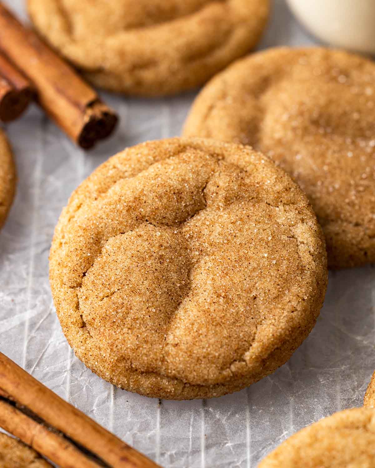 45 degree angle of snickerdoodle cookie showing golden brown exterior and speckled cinnamon sugar sugar.