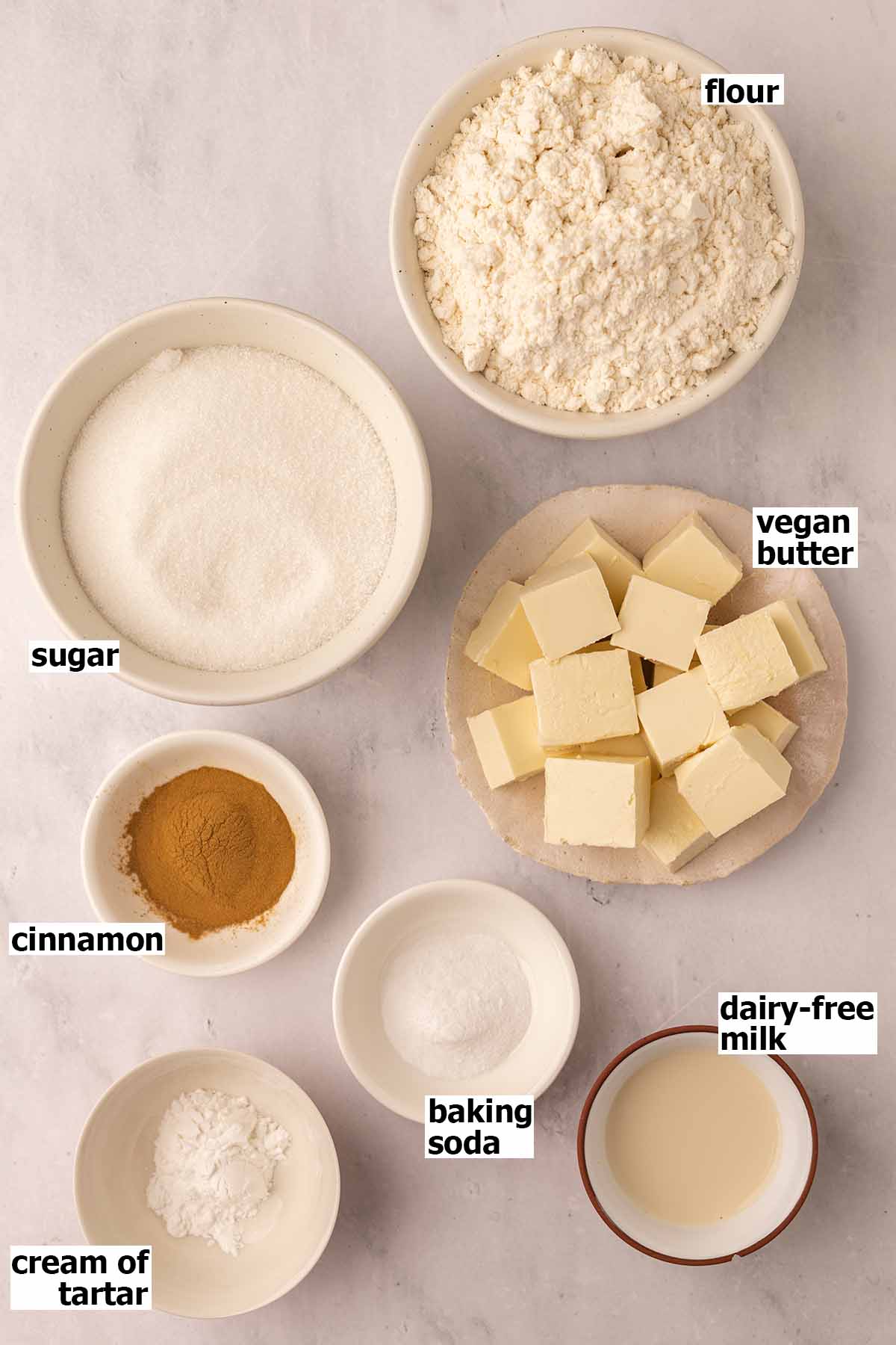 Flat-lay of ingredients in small dishes for snickerdoodle cookies.