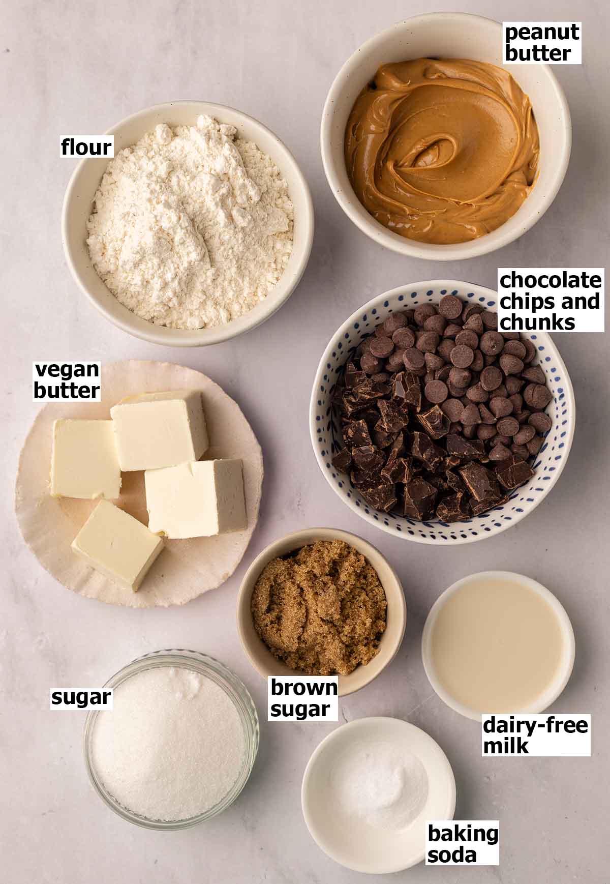 Small dishes containing ingredients for making peanut butter chocolate chip cookies.