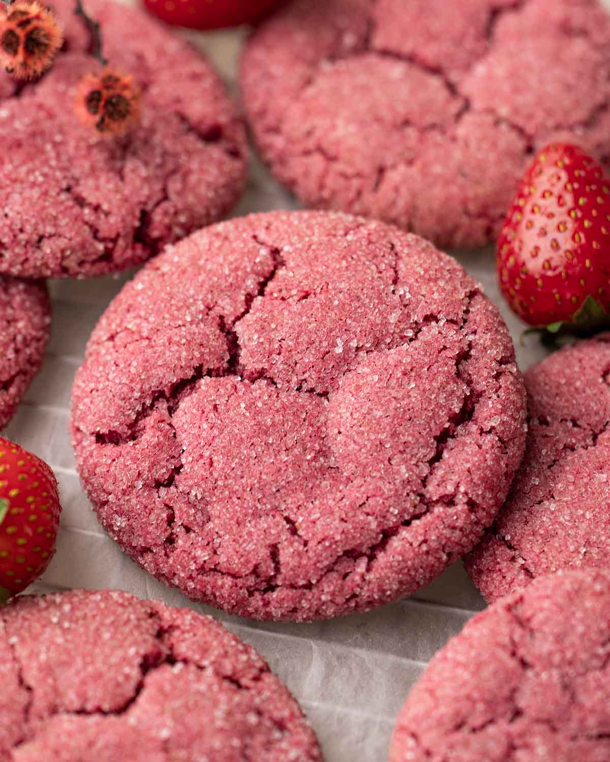 Close up of pink strawberry cookies on crumpled parchment paper.