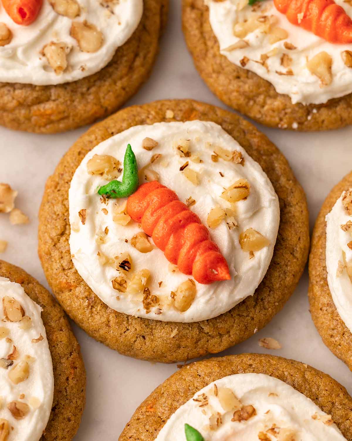 Close up of decorated cookie with a piped carrot shape on top.