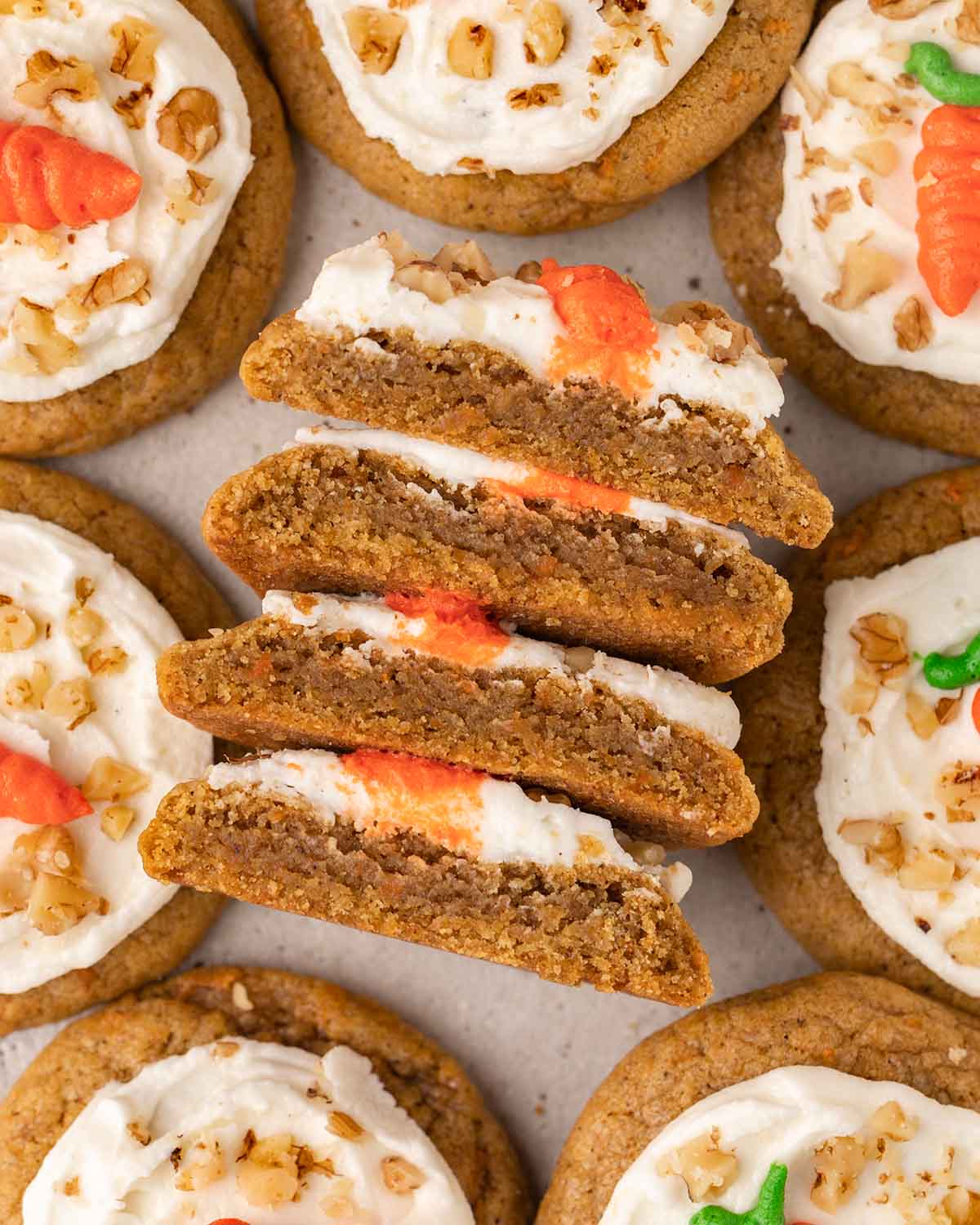 Close-up of four halves of cookies showing their dense texture and layer of frosting.