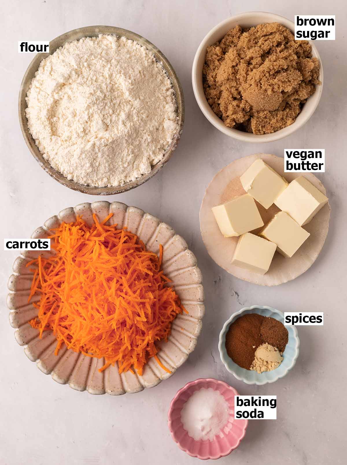 Flat-lay of ingredients in small dishes for carrot cake cookies.