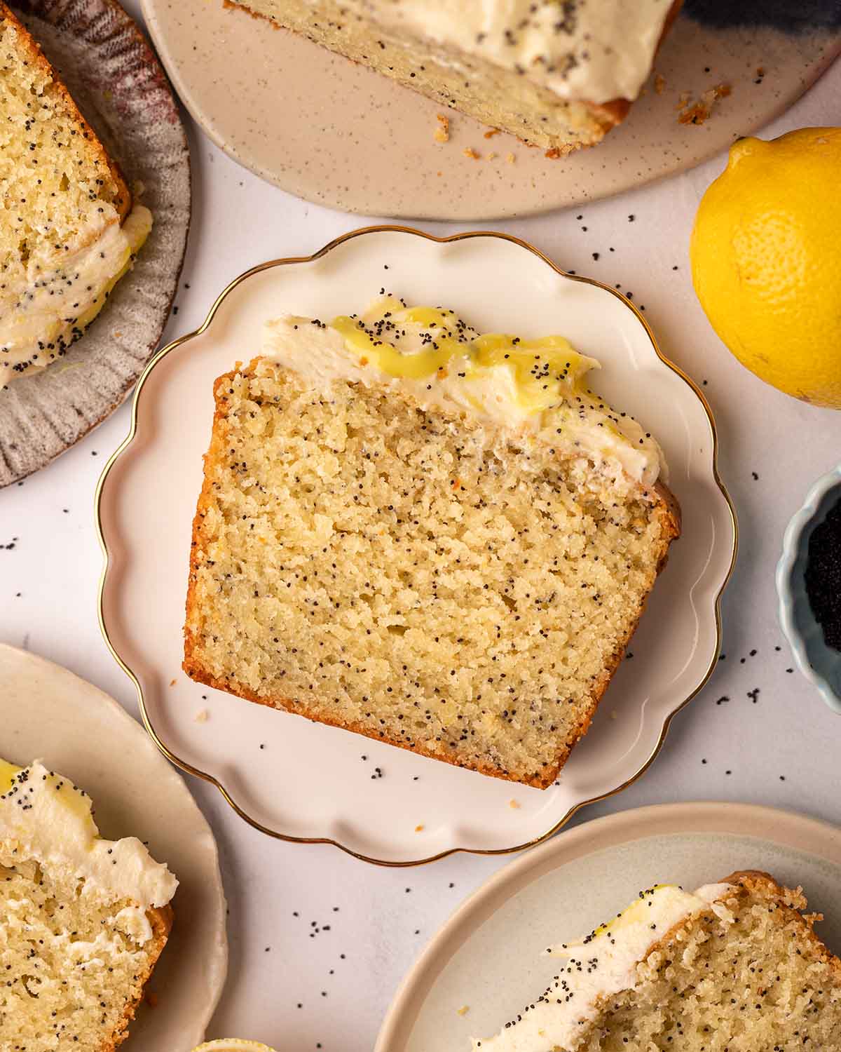 Flat-lay of slices of poppy seed cake on serving plates.