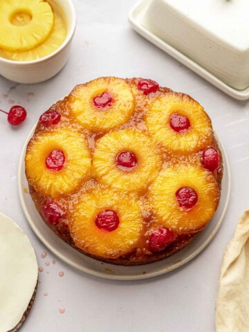 Classic pineapple upside down cake on plate with very glossy topping.