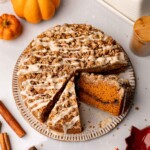 Vegan pumpkin coffee cake with two slices taken out revealing the cinnamon sugar layer in the middle of the cake.