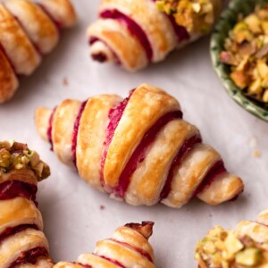 Close up of puff pastry croissant with raspberry jam filling.