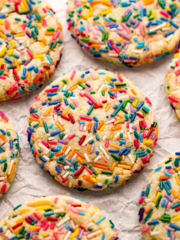 Close up of colorful vegan funfetti cookies on parchment paper.