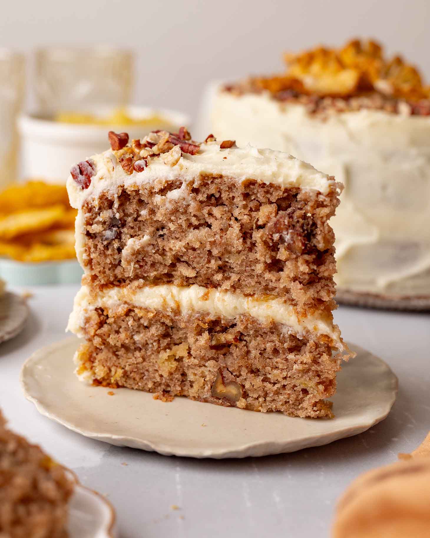 Slice of hummingbird cake standing upright on a small serving plate.
