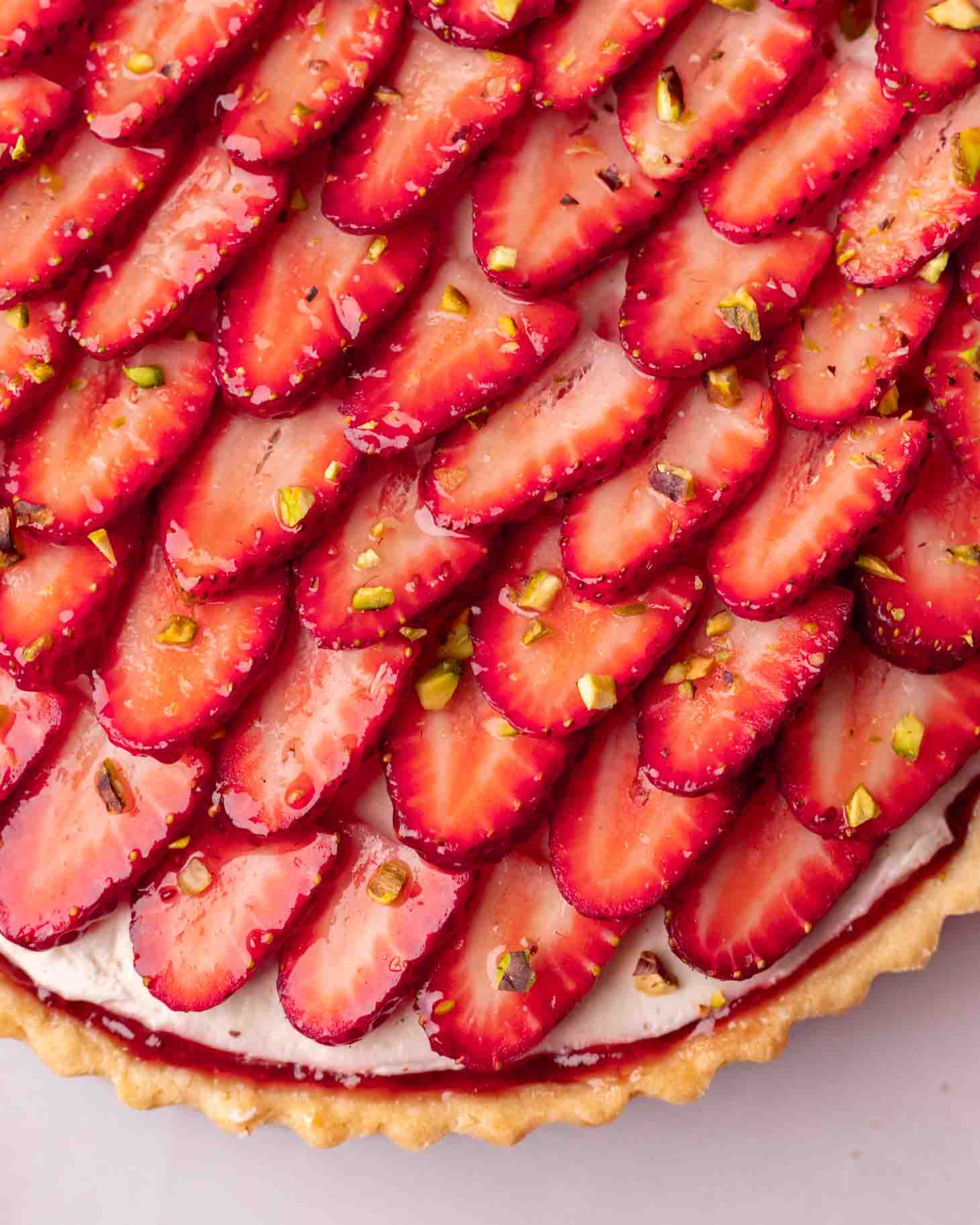 Close up of glazed sliced strawberries on tart.