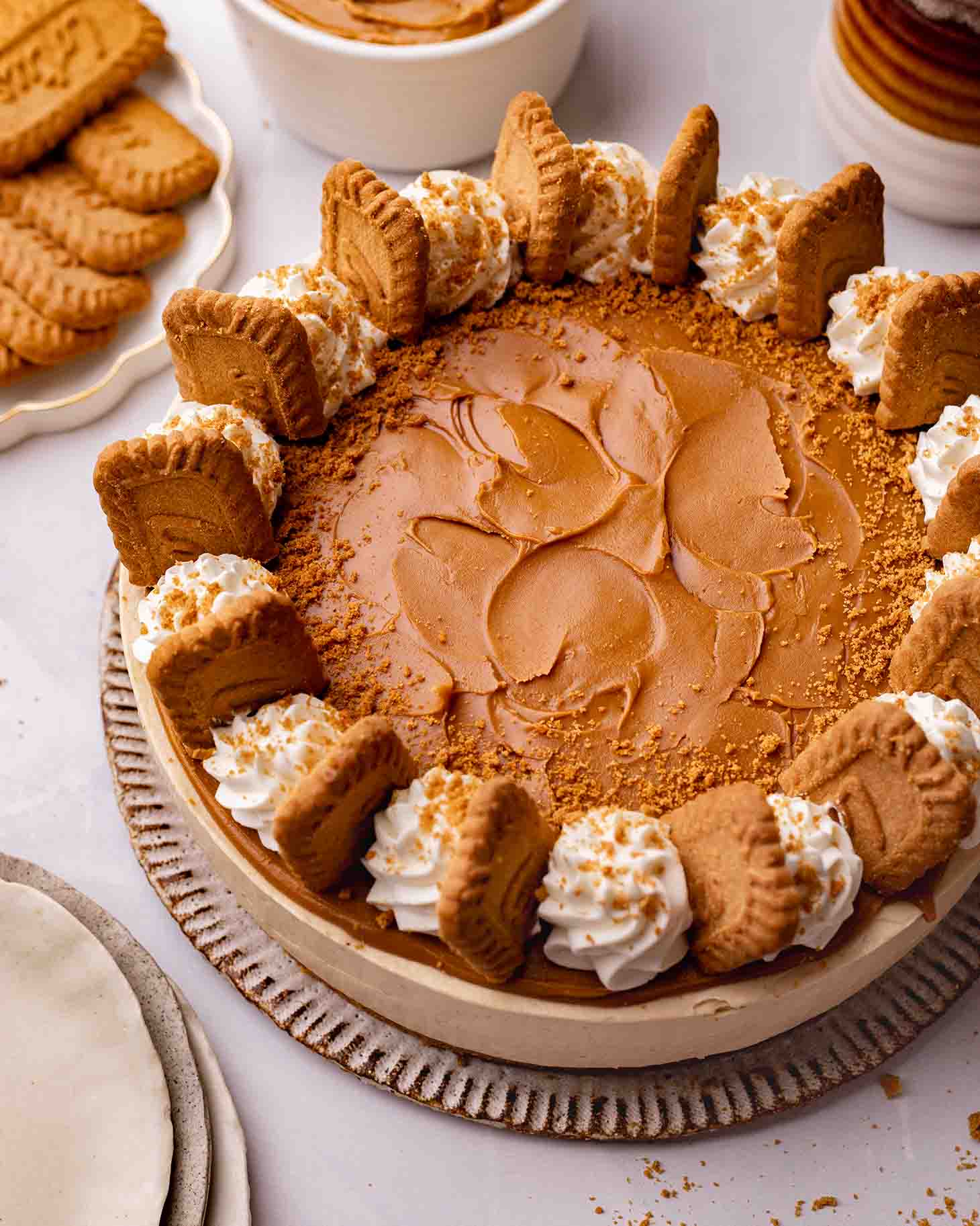 Biscoff cheesecake with decorations including Biscoff spread, whipped cream and Biscoff cookies.