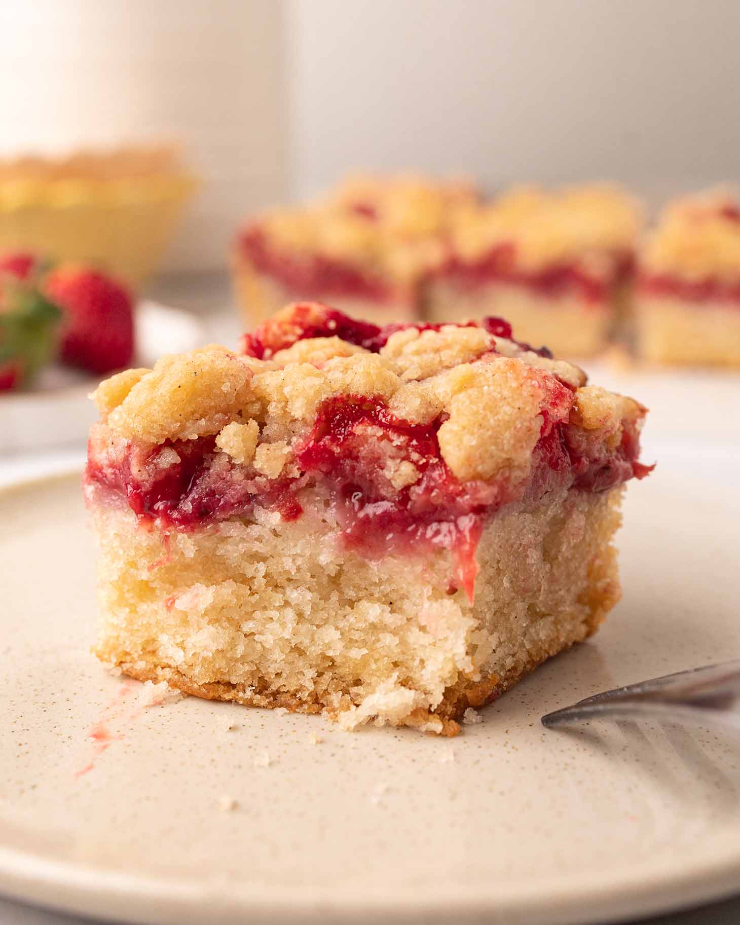 Close up of the crumb cake with a bite taken out revealing the dense but moist texture of the cake.