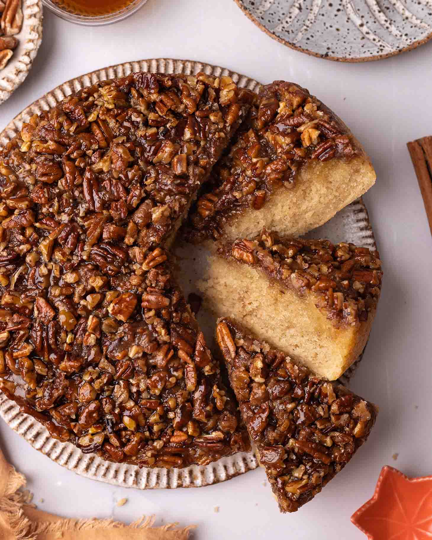 Close up of pecan upside down cake with a few slices cut out on their side to reveal their texture.