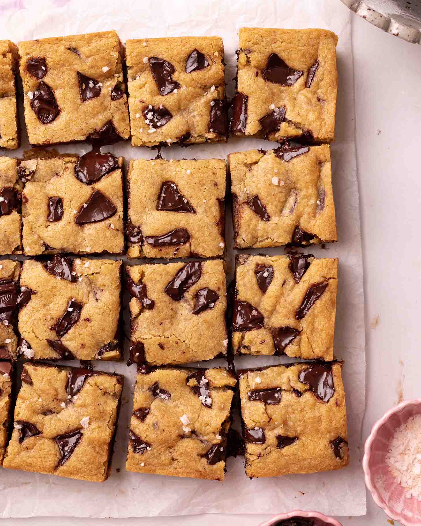 Cookie bars sprinkled with salt on parchment paper.
