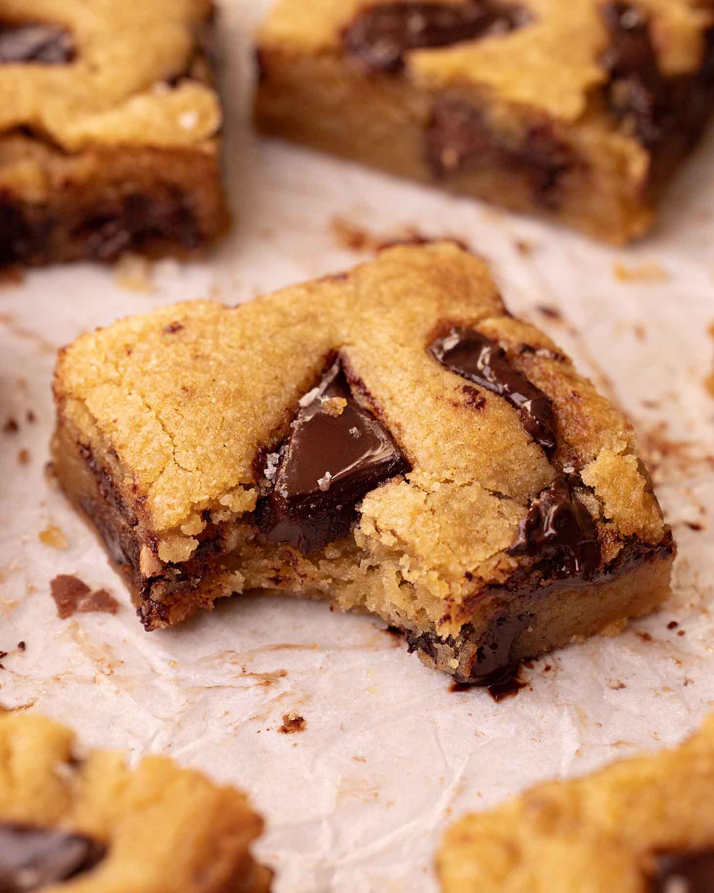 Close up of one chocolate chip cookie bar with a bite taken out.