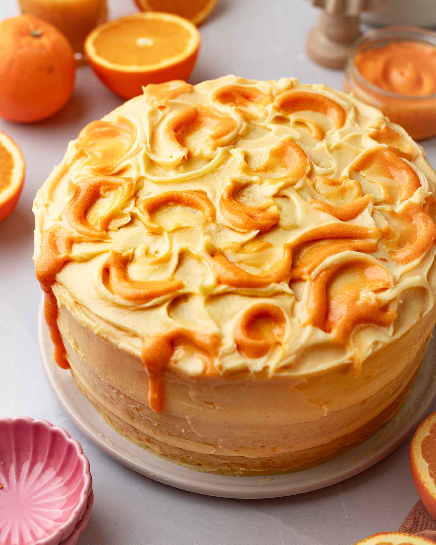 Fully decorated orange cake with bright orange-colored curd swirled into the top.