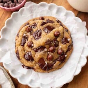 Large vegan chocolate chip cookie on parchment paper.