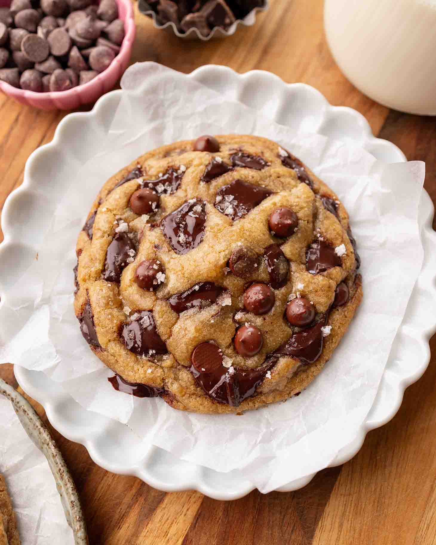 Large vegan chocolate chip cookie on parchment paper.