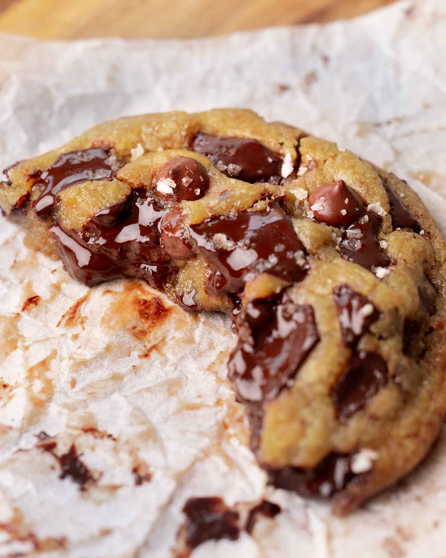 Close up of half a large cookie focusing on soft gooey interior and melty chocolate chips.