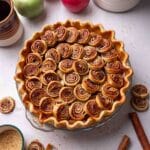 Apple pie with cinnamon pastry swirls on top.