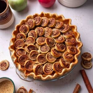 Apple pie with cinnamon pastry swirls on top.