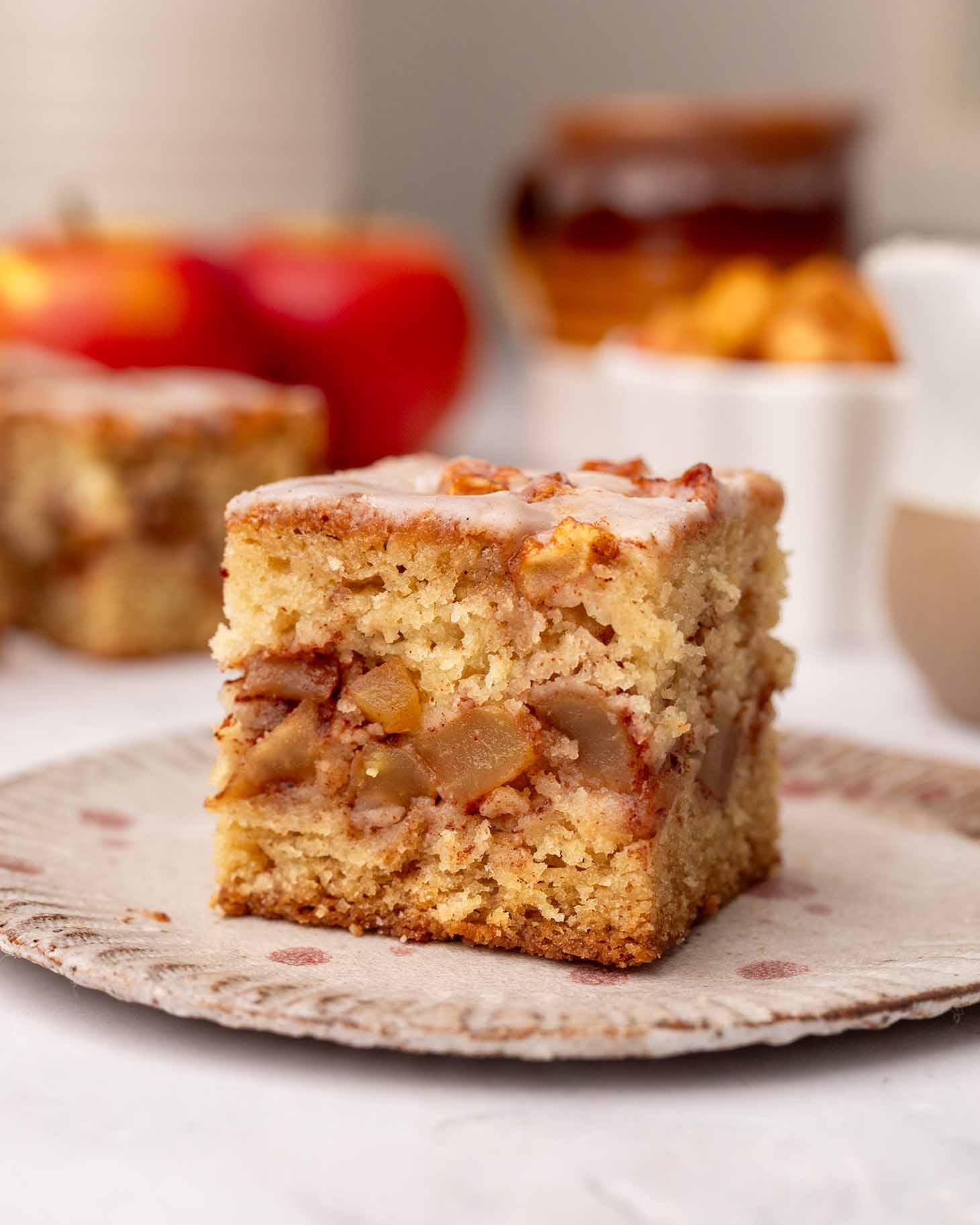 Close up of one slice of apple fritter cake on a plate.