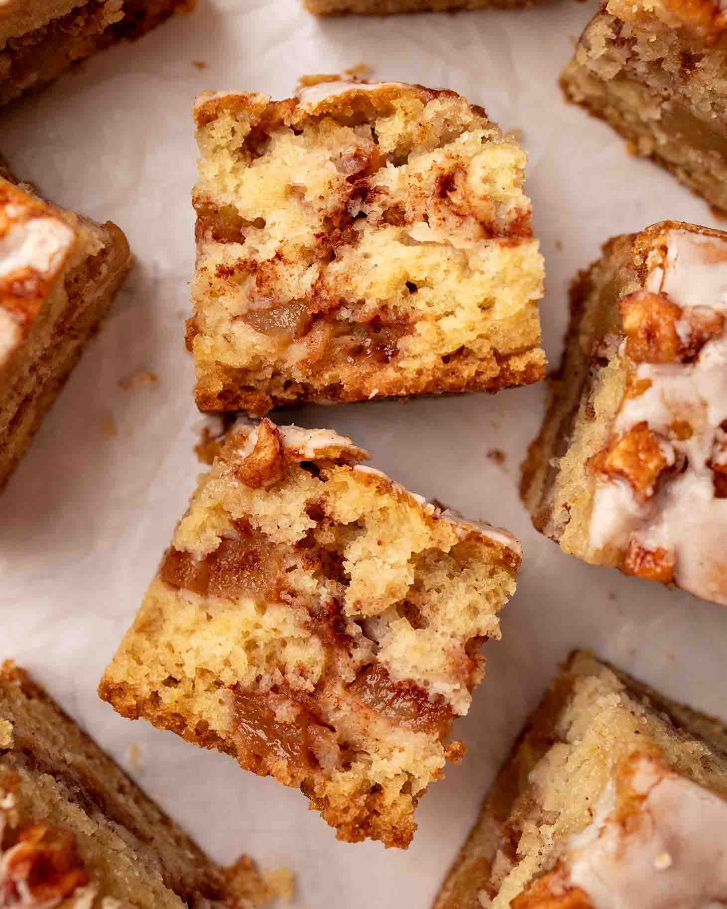 Apple fritter cake torn into half revealing fluffy golden cake and gooey cinnamon apples.